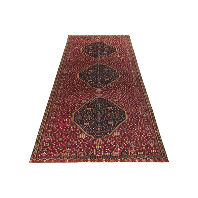 A rare gallery size vintage kilim rug originating from Turkey circa 1950-1960. The classic rendering carries an archaic...