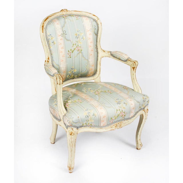 This is a beautiful antique pair of Louis Revival French shabby chic cream painted fauteuils, or open armchairs, late 19th...