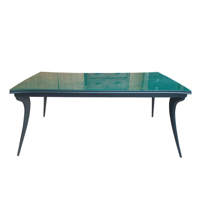 Refined vintage table from the 1950s/60s, featuring a green faux-marble glass top and a black lacquered wooden frame. The...