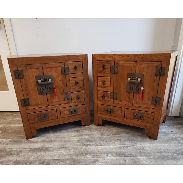 Add these exceptional pair of vintage Asian cabinet chests, crafted from beautifully grained elmwood with a warm, honey-...