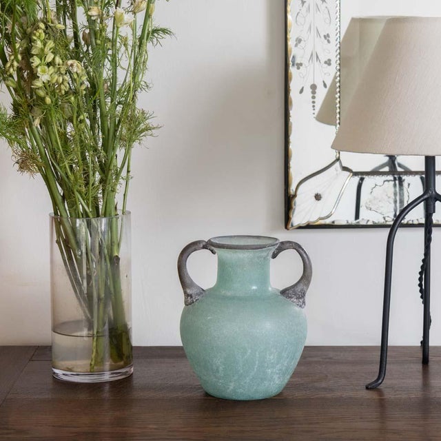 Vintage Italian Scavo vase in a beautiful amphora shape from the 1960s. Made of frosted green glass with glass handles on...