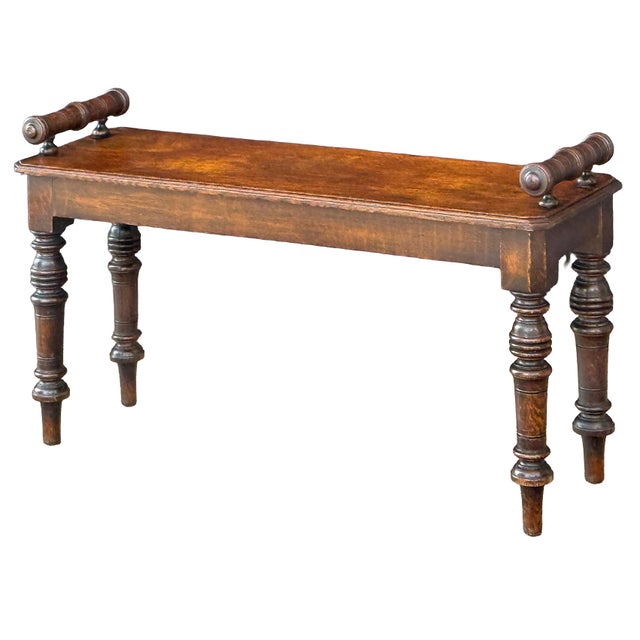 A fine English hall bench or window seat or stool of handsomely patinated oak from the 19th century, featuring turned...