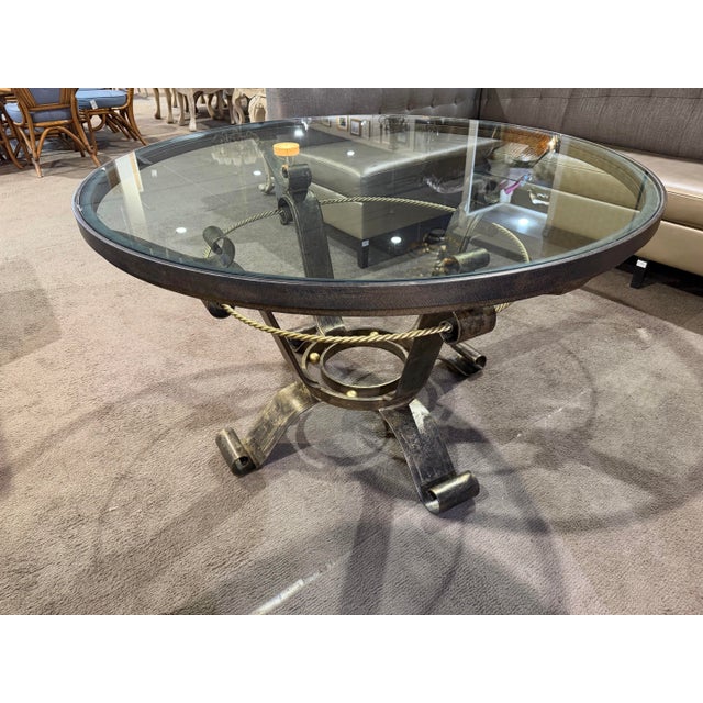 This elegant scrolled iron base glass-top table is a striking blend of artisanal metalwork and timeless design. Featuring...