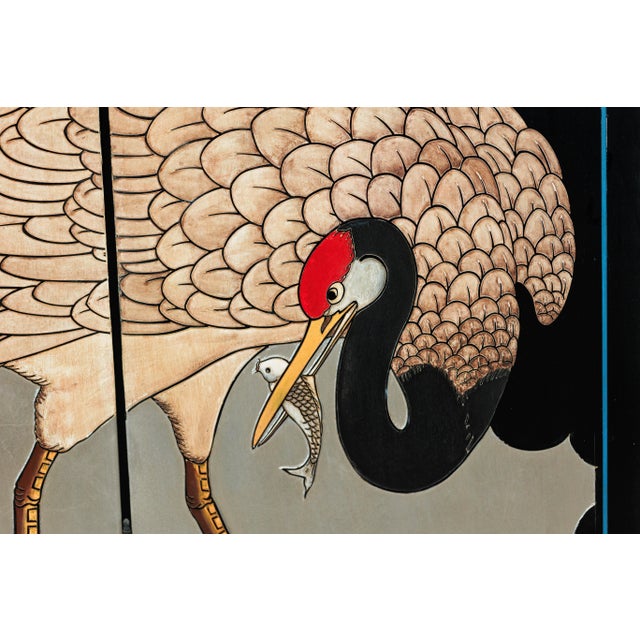 This vintage Chinese four-panel screen features a striking depiction of red-crowned cranes set against a luminous silver-...