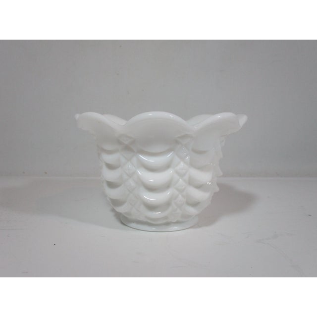 Elegant designed milk glass bowl. The bowl has a scalloped top rim with high relief layers of scallops around the body....