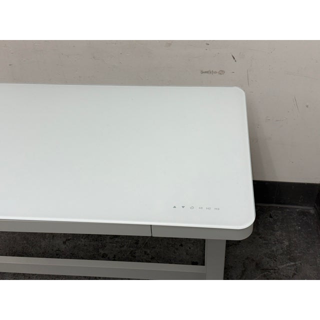 Design Plus Gallery presents a Geller Adjustable Height Desk from Tresanti. The desk pairs a white rectangular glass top...