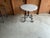 Kreiss iron decorative iron base with travertine top. Base is solid iron. Top is cream colored travertine. Table is in...