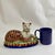 Wonderful recumbent mantle cat painted in folk art whimsical colors. I love the ball in his front pays. Nice large size...