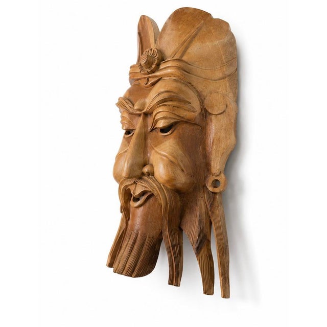 A commanding vintage hand-carved tropical wood wall sculpture depicting a Chinese-style bearded warrior or official...