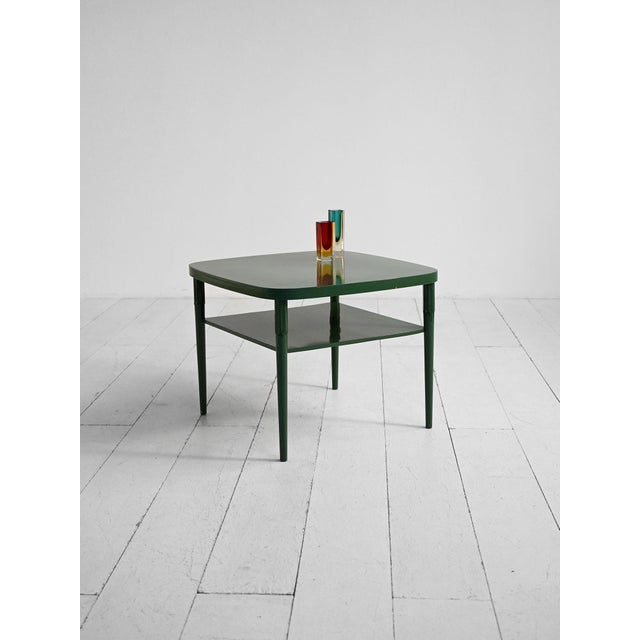 Green lacquered wooden coffee table with rounded top and lower shelf. Scandinavia, 1950s–1960s. A mid-twentieth-century...