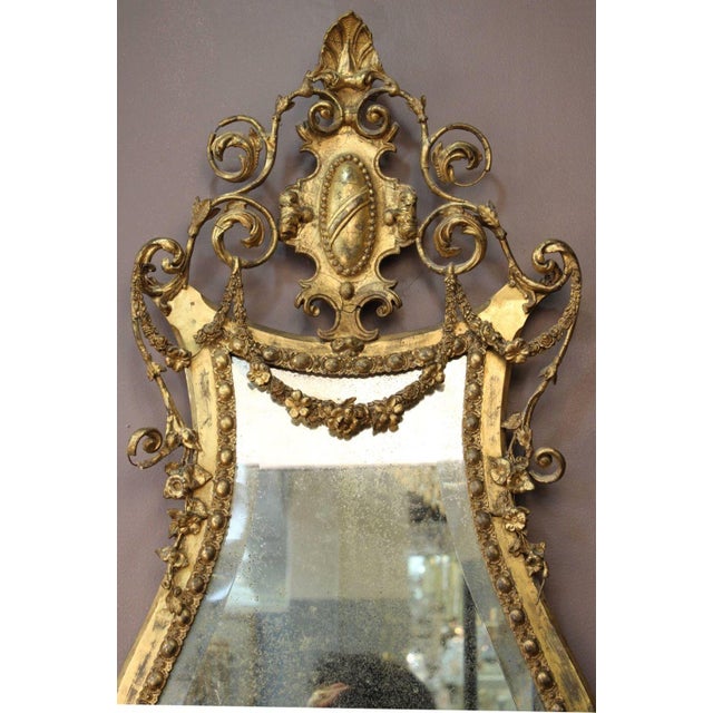 George III Giltwood Girandole Beveled Glass Mirror, the ornately carved foliate lyre-shaped frame with gilt swags encasing...