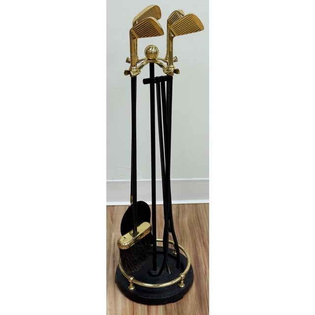 Vintage four piece brass and iron fireplace tool set on stand. Each handle topped with a golf club on round stand topped...