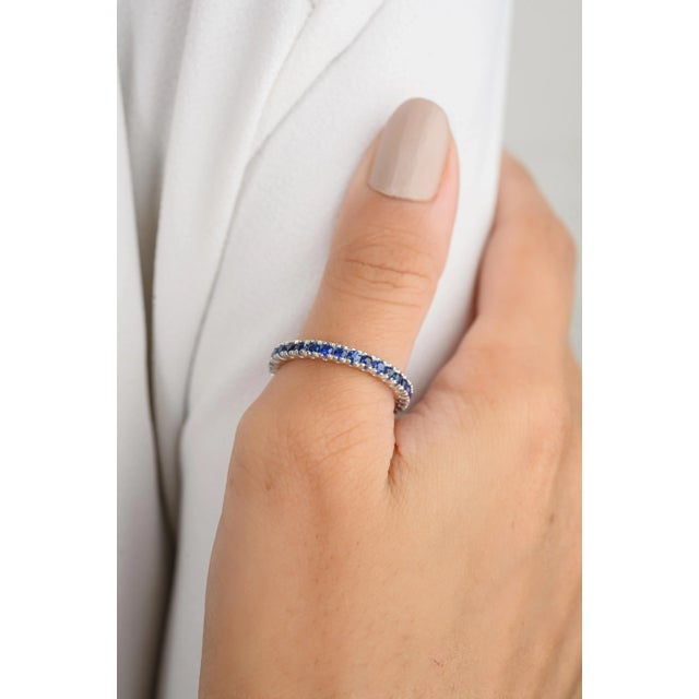 This modern band ring features a stunning round-cut blue sapphire set in 18k white gold. The sleek design highlights the...