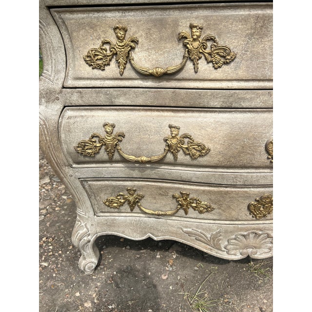 Elegant Louis XV style commode featuring a graceful bombe-shaped silhouette, three spacious drawers, and ornate gilt...
