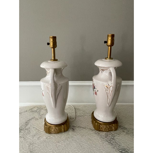 These floral lamps will adorn any room with charm. Bright white large ceramic double arm lamps adorned with 22k gold trim....