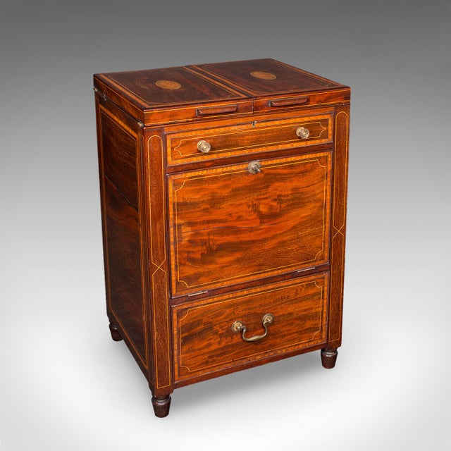 This is an antique cocktail cabinet. An English, mahogany and boxwood counterweighted dry bar, dating to the late...
