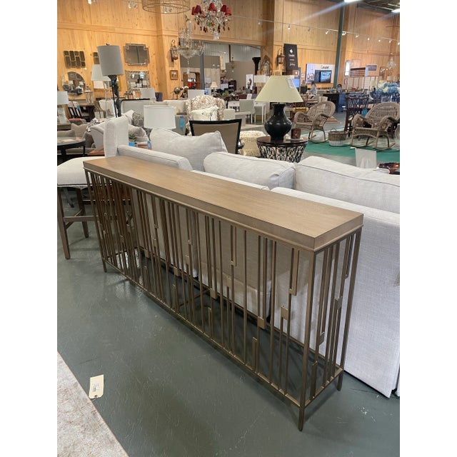 This Lexington Studio console table blends modern elegance with timeless sophistication. The sleek rectangular wood top is...