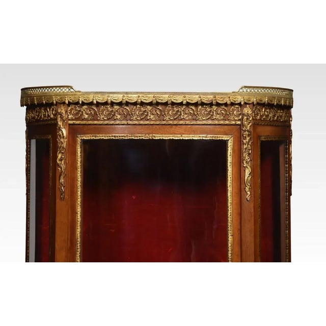 Description Walnut display cabinet, the shaped marble top with raised three quarter ormolu gallery, above glass sides and...