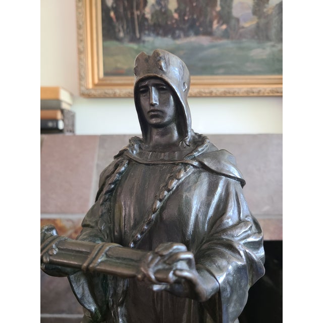 Impressive patinated bronze statue of a figure in medieval attire holding a collection of bound scrolls. On the backside...
