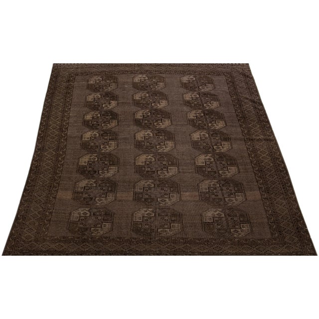 Beautiful antique Turkmen hand-knotted wool rug with a brown color field in a gorgeous all-over Gul pattern design. This...