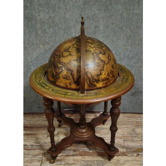 World map/Globe bar on a stand, a decorative piece inspired by antique designs, resting on a turned wooden base. The...