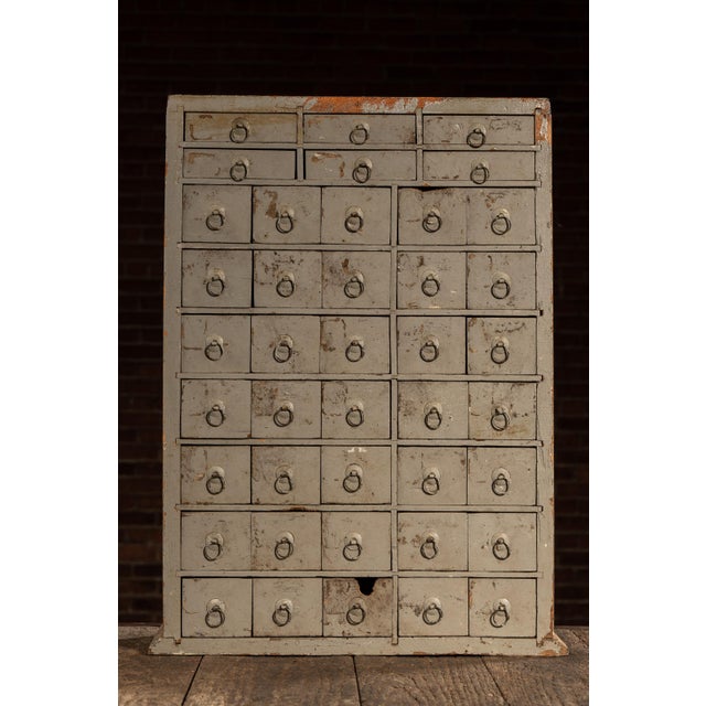 c. 1890s-1910s; Munyon Remedy Company - Philadelphia, PA Painted pine apothecary cabinet with a bank of small drawers and...