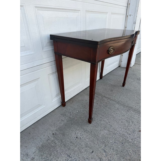 We have a beautiful vintage mahogany flip top console table for sale. It features a beautiful Federal Hepplewhite inspired...