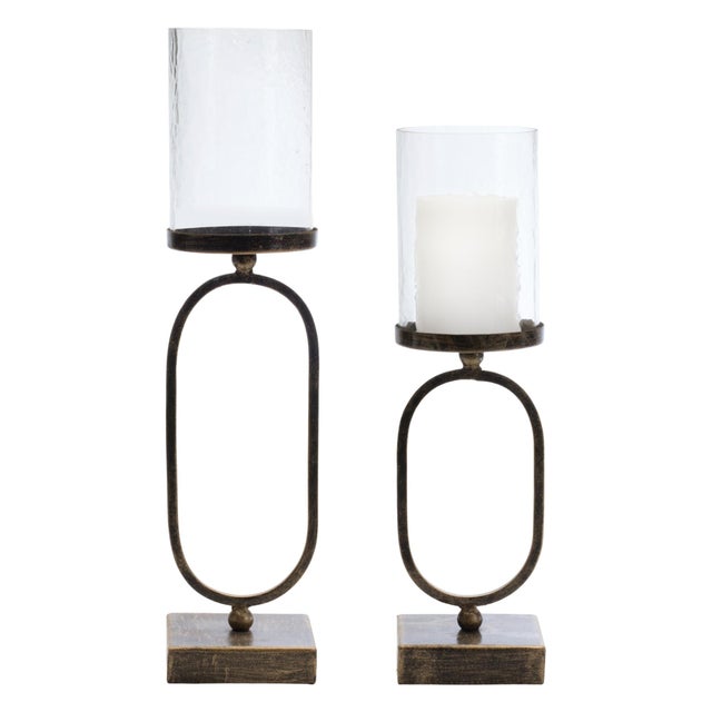 Elevate your home ambiance with this stunning set of Rust & Black Metal Candle Holders with Glass Hurricane. Featuring...