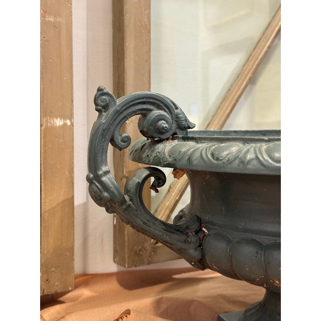 This is a late 19th century antique garden urn. It is made out of cast iron. It is in the French Neoclassical style. It...