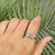 Handmade three-stone ring crafted in 925 sterling silver, featuring 0.89 carats of marquise-cut emeralds accented by 0.03...