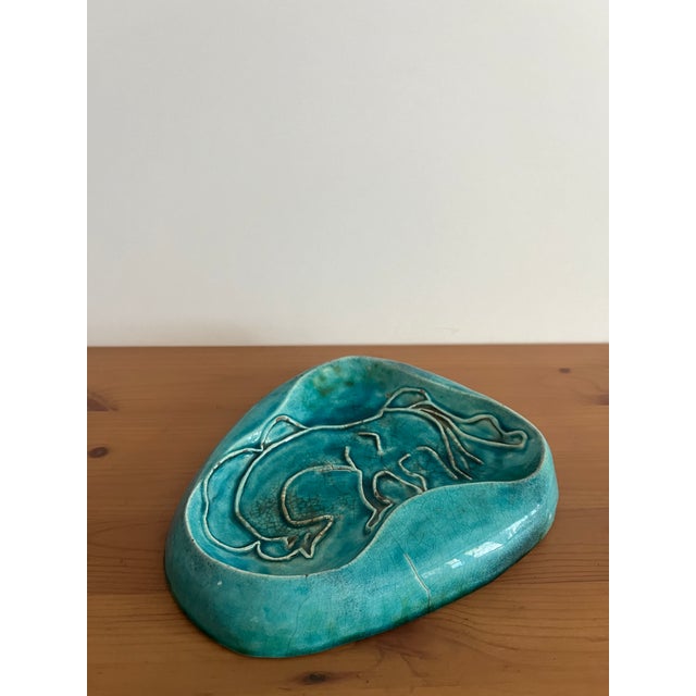 A signed and dated teal glazed pottery ashtray. Signed Catherine de Vol 1951. Some hairline cracks. Please see photos. 8”...