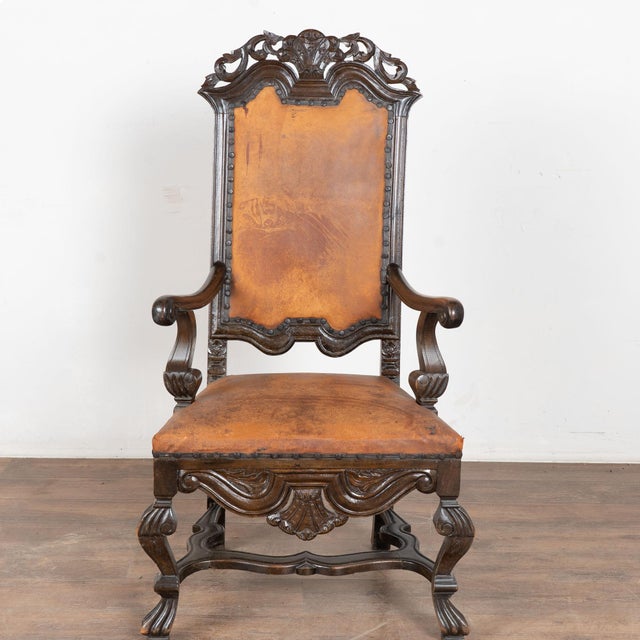 Late 19th century Swedish carved armchair, crafted in dark oak and upholstered in vintage leather. Decorative rococo...