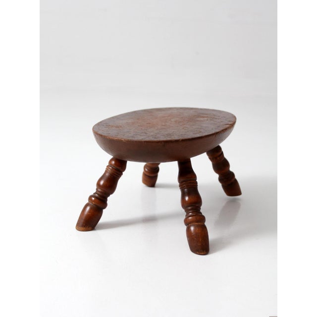 A charming vintage Early American wood footstool featuring classic turned legs and a beautifully aged patina. The oval top...