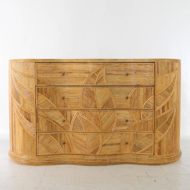 Incredible curved rattan chest of drawers with four drawers featuring a foliage motif. The foliage adorning the front and...
