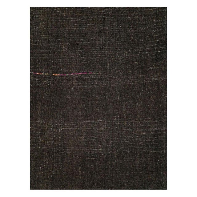 A vintage Turkish flatweave Kilim gallery carpet handmade during the mid-20th century in shades of black and dark brown....