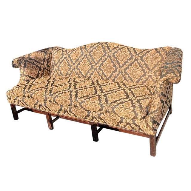 Antique Chippendale-Style Camelback Sofa -The antique couch features a classic design with ornate upholstery,...