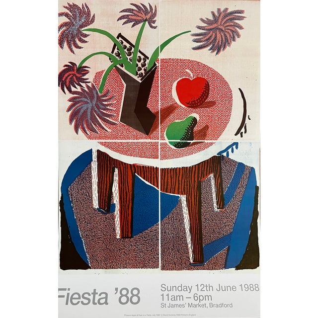 This amazing poster, featuring David Hockney’s 1986 painting Flowers, Apple & Pear on a Table, was created for the...