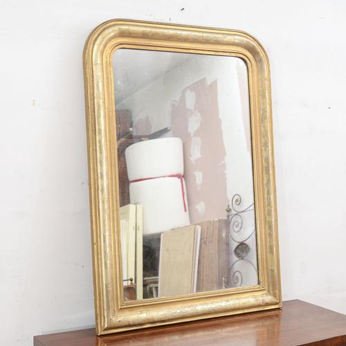 This elegant gilded mirror is a refined example of antique craftsmanship, ideal for those seeking to add a touch of light...
