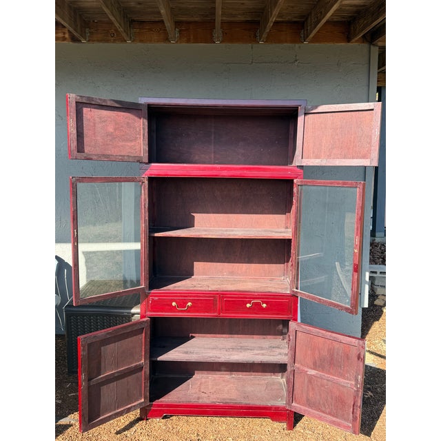 This is a solid wood, antique is china cabinet in an Asian or Chinoiserie style. It is constructed from a dark wood,...