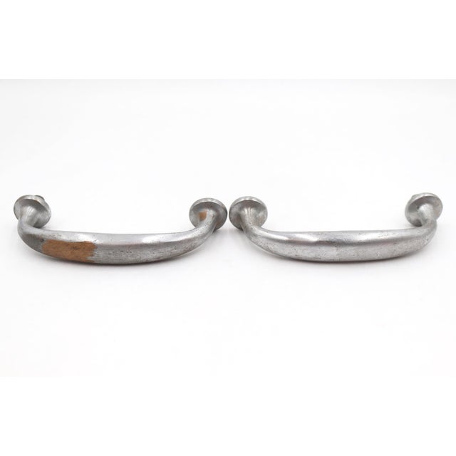 Reclaimed door pull handles made of a nickel finish over brass in a standard design. The original mounting screws are not...