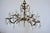 A beautifully substantial Spanish chandelier with a warm aged brass finish, sculptural cast detailing, and tiers of...