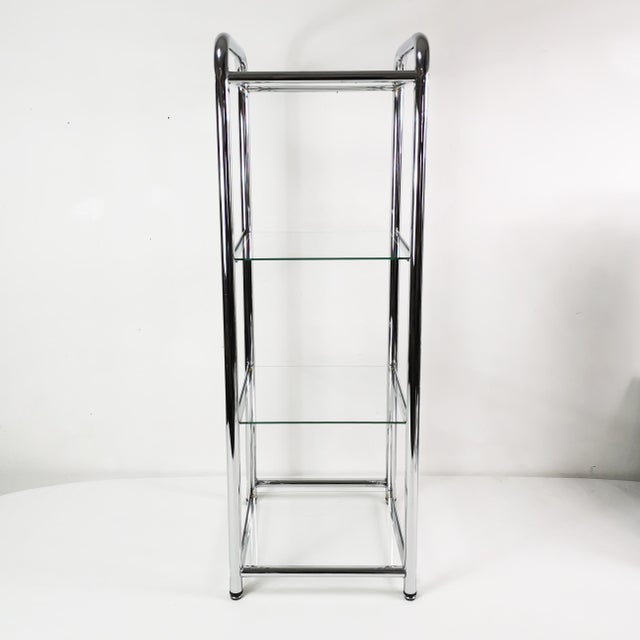 Etagère - shelving unit, Italian, 1980s. It features a simple, spacious design. Made of chrome metal and glass shelves. It...