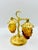 This glorious & rare amber-colored glass hanging grape & gold-tone salt and pepper shaker set is the height of mid-century...