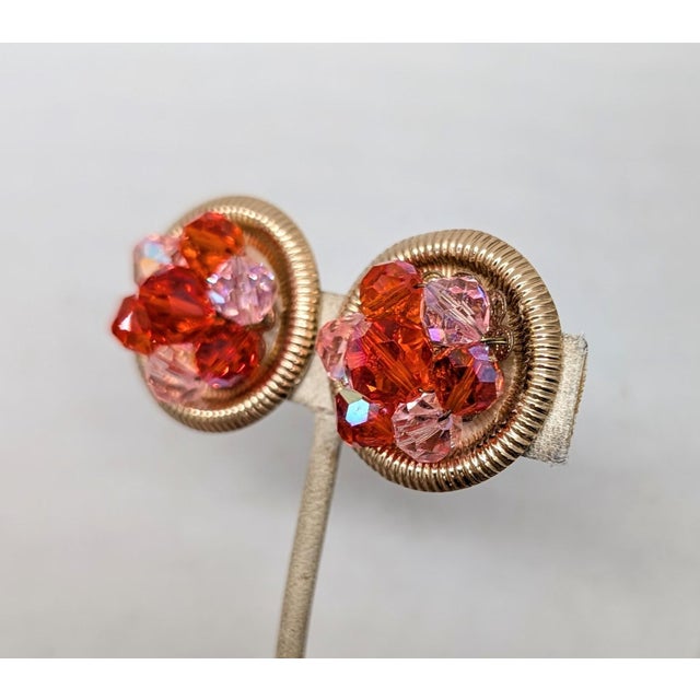 Late 1950s or early 1960s round goldtone with ribbed edges with red and pink aurora borealis cut beads in the center...