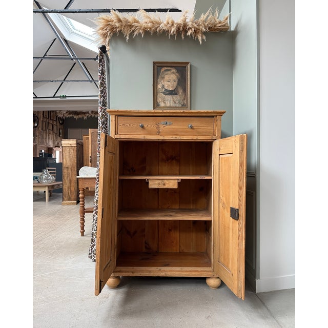 A tall, solid pine sideboard from the late 19th century, of alsatian or germanic origin. At 140 cm high, it commands...