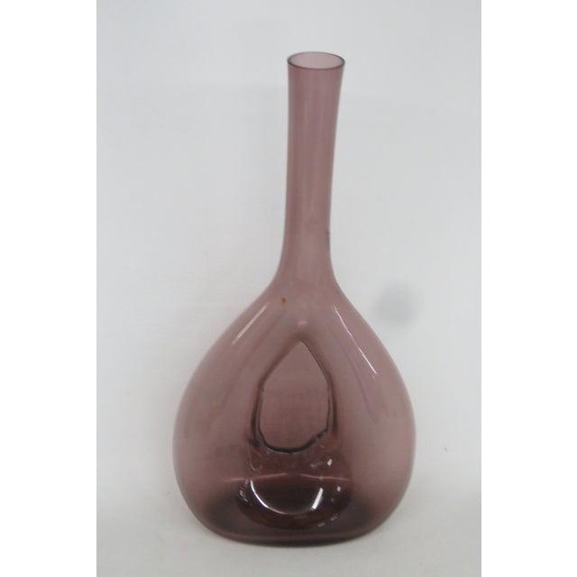 This beautiful Swedish Pinched Bulb Vase is made of glass. This vase presents a lovely purple color that perfectly...