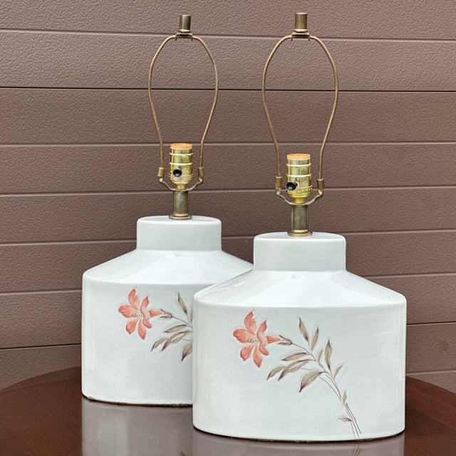 Beautiful pair of vintage ceramic table lamps each with a single lily flower hand painted on front side. Measures 22” tall...