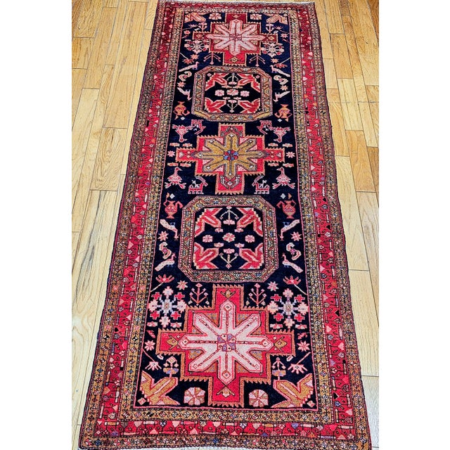 A vintage Persian Hamadan gallery rug, hand-knotted in western Iran in the early 20th century. This elongated gallery-...