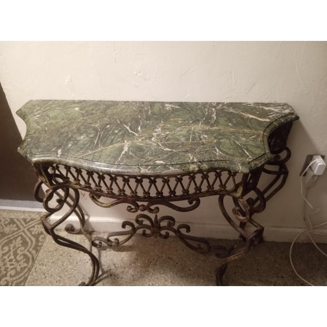Beautiful vintage French-style console table featuring a genuine green variegated marble top and a heavy, ornately crafted...