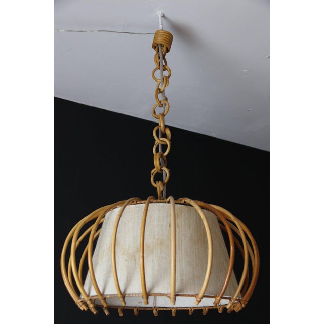 Magnificent Mid-Century pendant light inspired by the Riviera, entirely crafted from hand-bent rattan and woven wicker,...